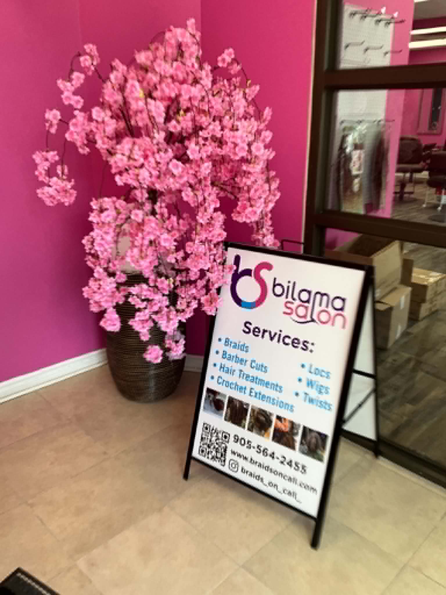 Bilama Salon entrance with branded services sign and pink blossom tree